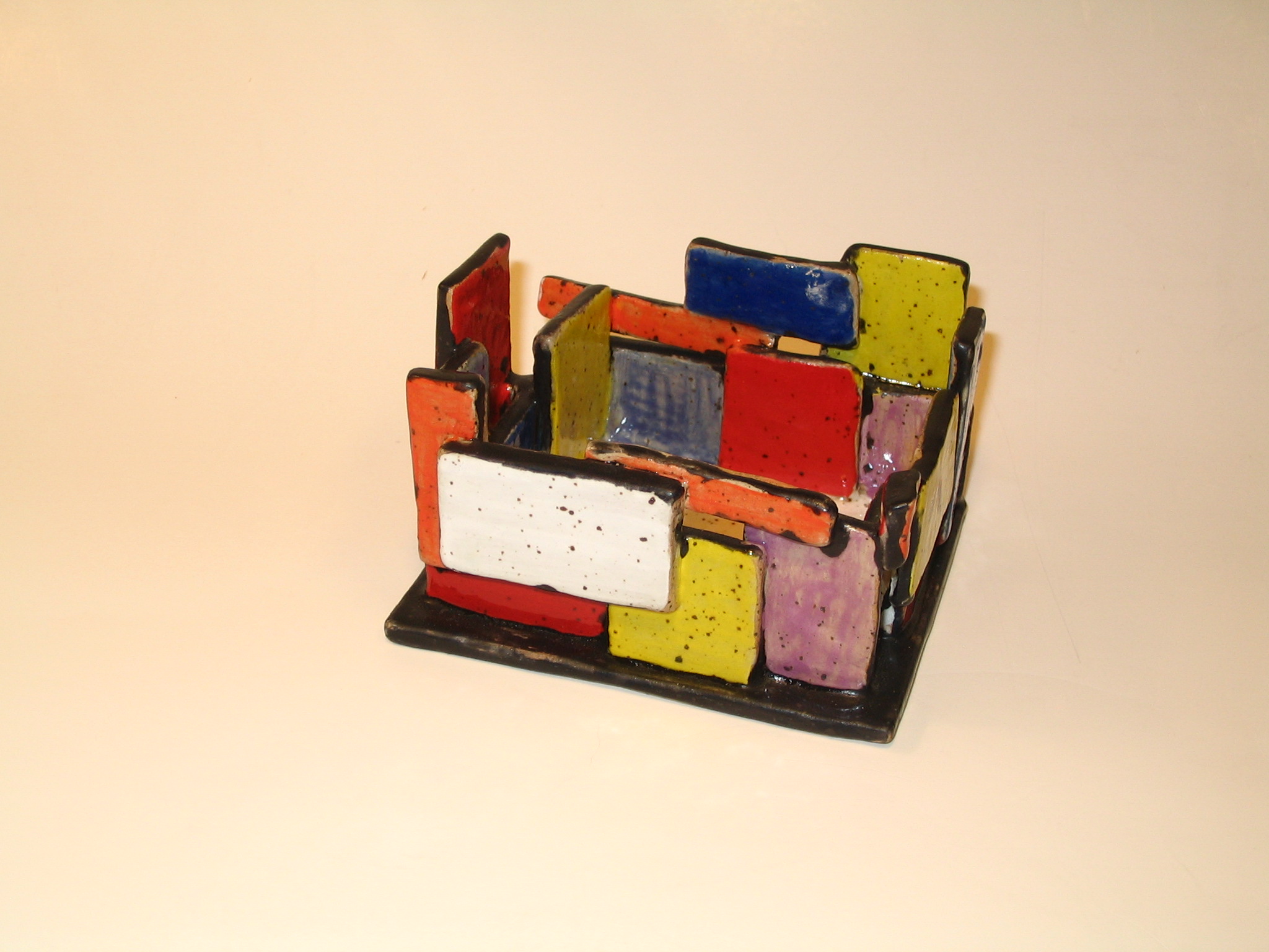 Small open box made with speckled clay sraps. Colours outlined in black.