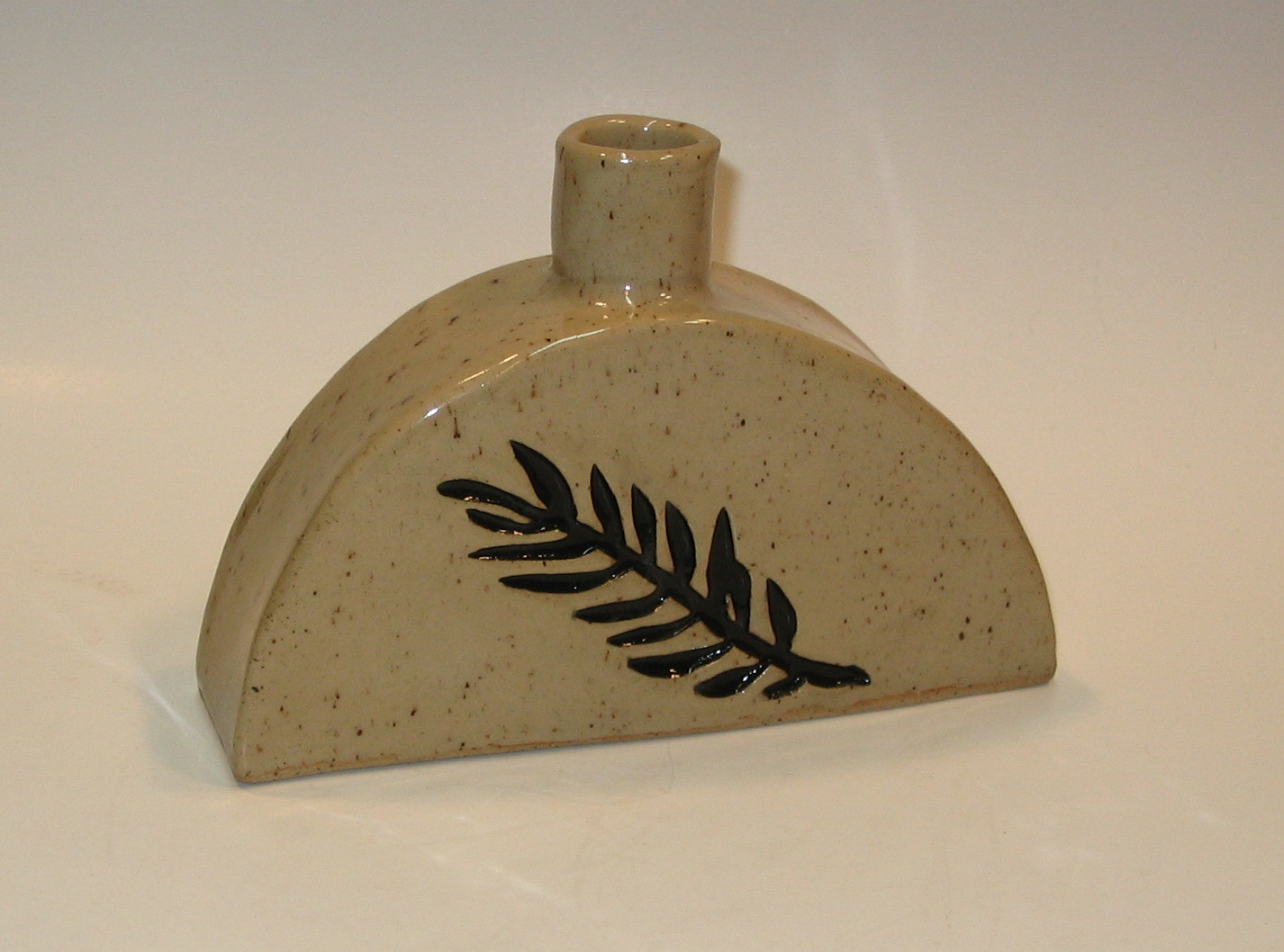 Vessel in speckled clay with leaf impression. Can be decorative or used as container.